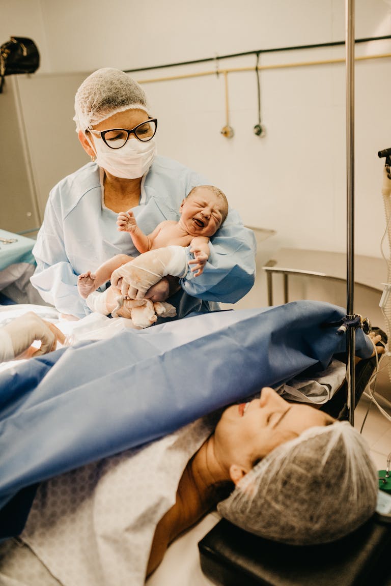 A doctor holds a newborn baby in a hospital setting post-delivery. First 48 Hours After Birth: What You Really Need