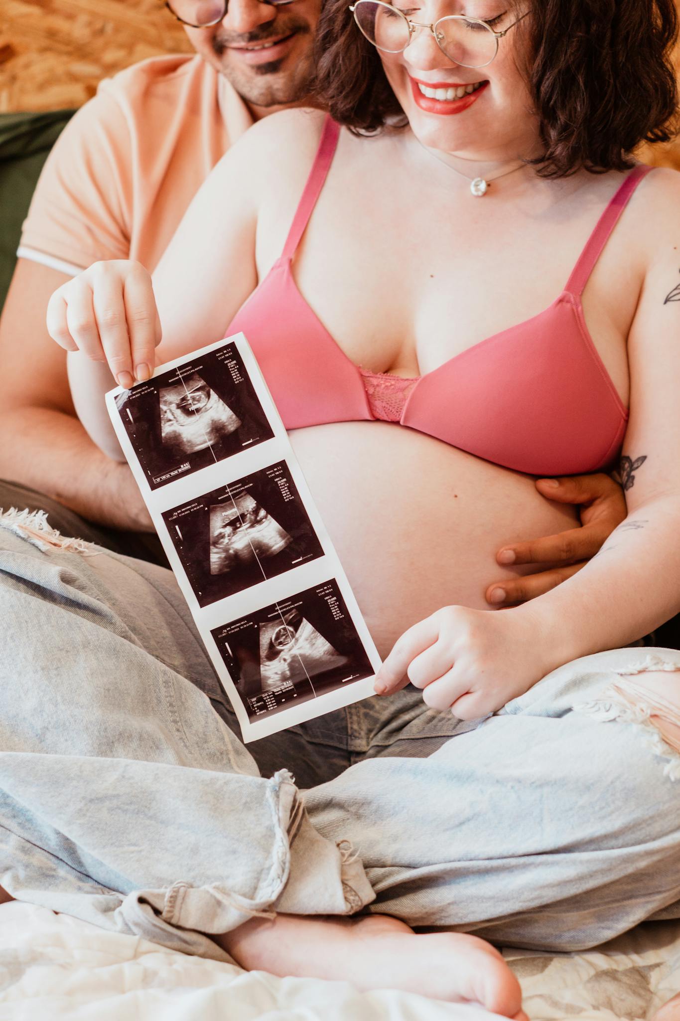 Happy couple holding ultrasound image, embracing pregnancy together.