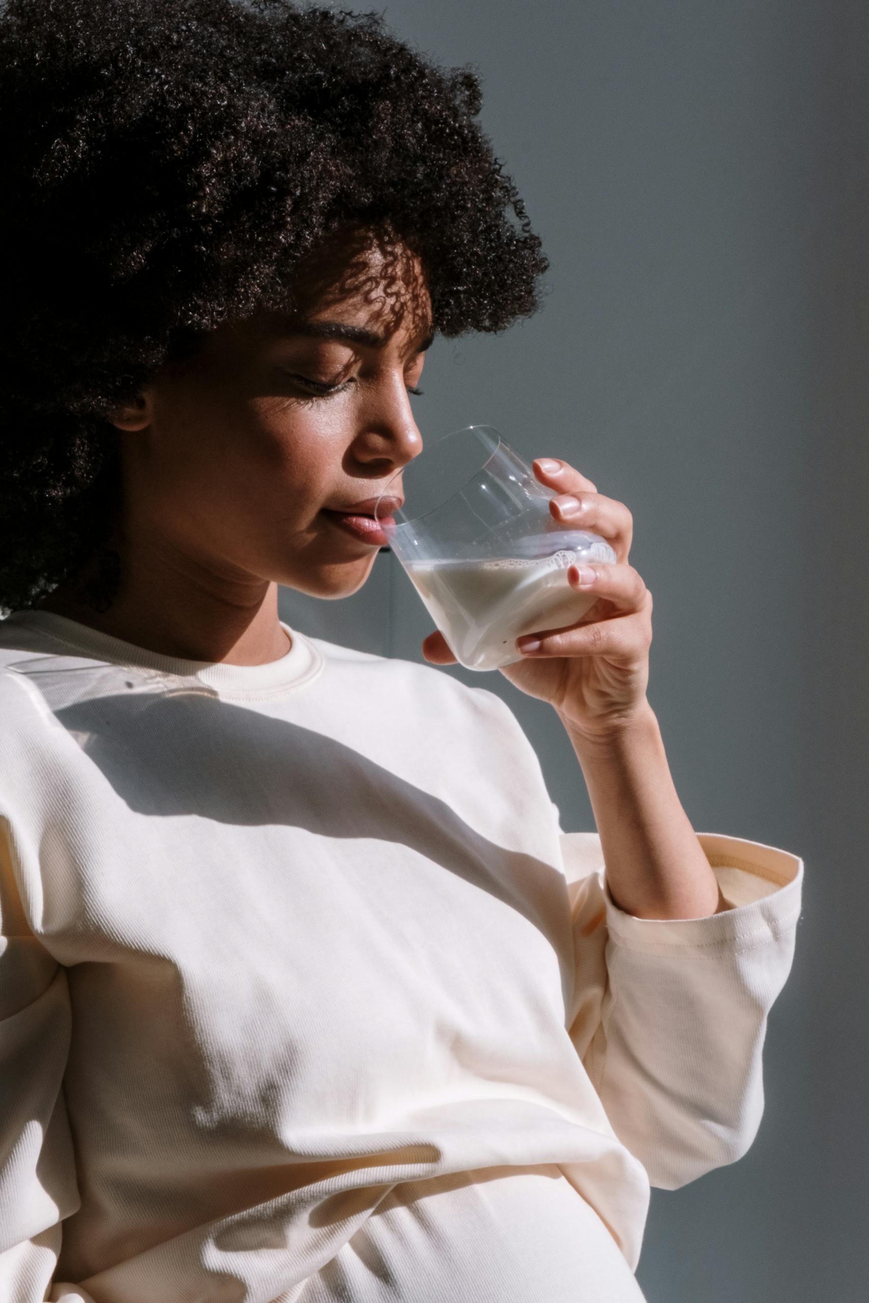 Pregnant African woman enjoying a glass of milk, symbolizing health and maternal care.