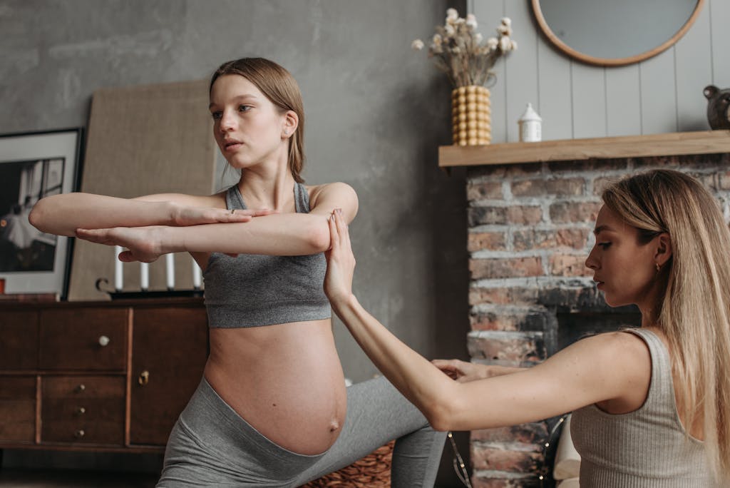 Pregnant woman doing yoga at home with a personal trainer for a healthy lifestyle. Top 5 Prenatal Exercises You Can Do at Home