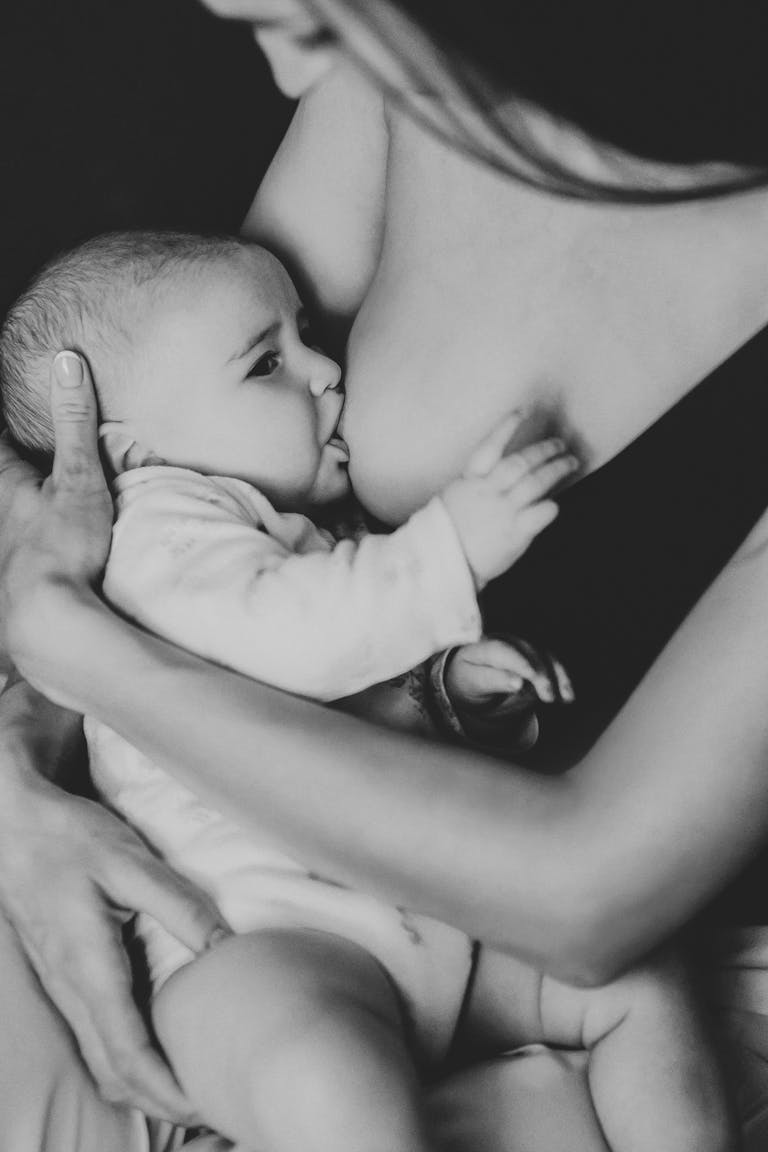 Tender black and white portrait of a mother breastfeeding her baby, showcasing motherhood and care. Breastfeeding Hacks That Actually Work