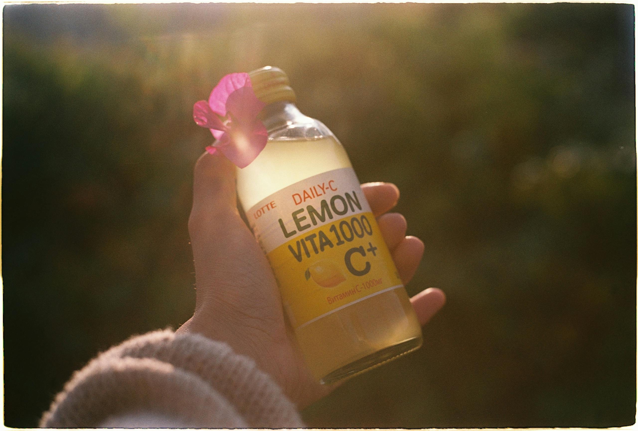A hand holding a lemon-flavored vitamin drink bottle outdoors in sunlight. How to Boost Immunity During Pregnancy: 9 Safe & Natural Ways