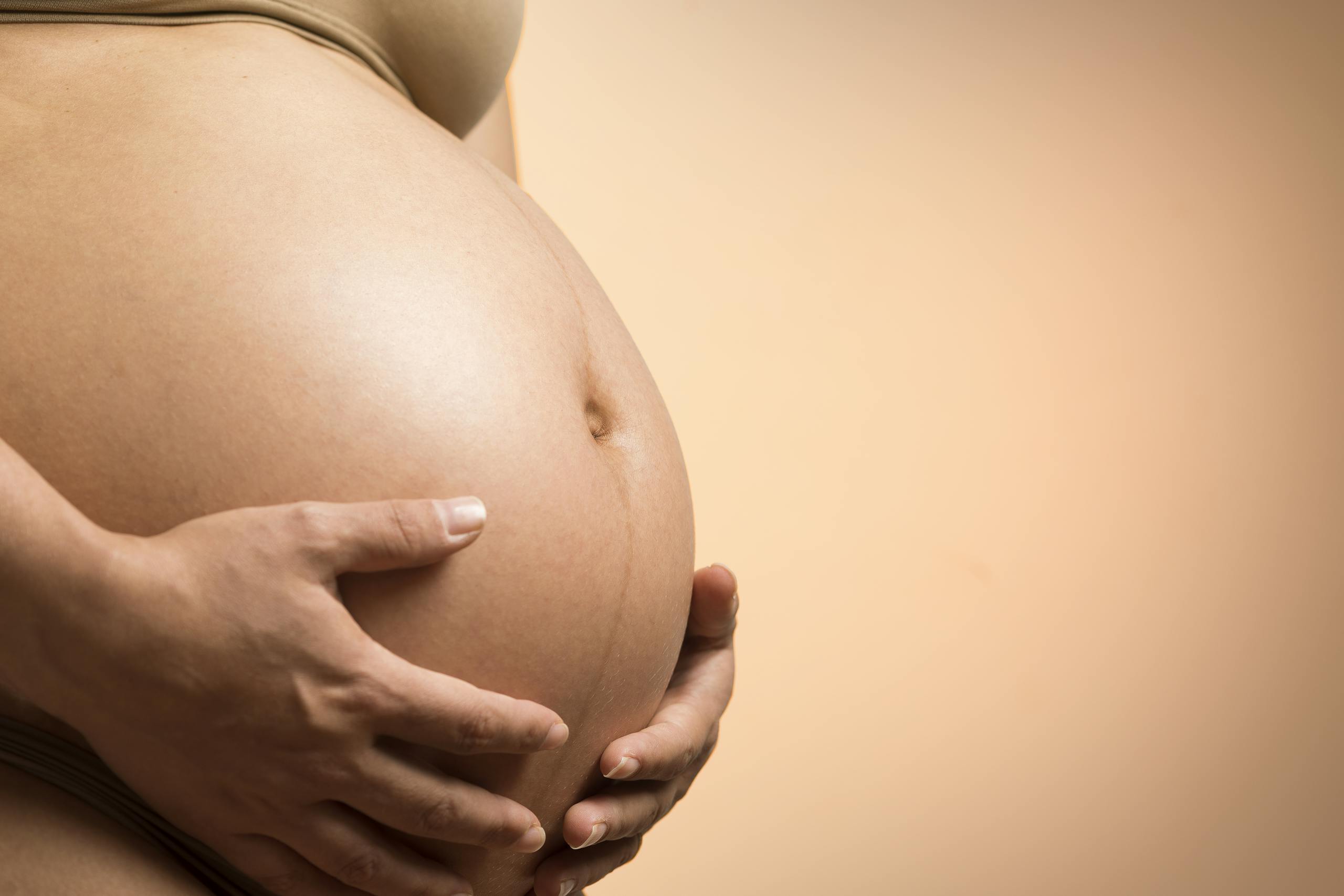 A tender close-up of a pregnant woman's hands holding her belly, symbolizing maternity and love. 🌸 Week 31 of Pregnancy: Baby’s Growth Spurt & Your Journey of Strength